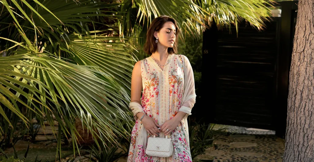 Shop assistants carefully place Faiza Saqlain's garments on display racks, preparing for the latest seasonal launch.