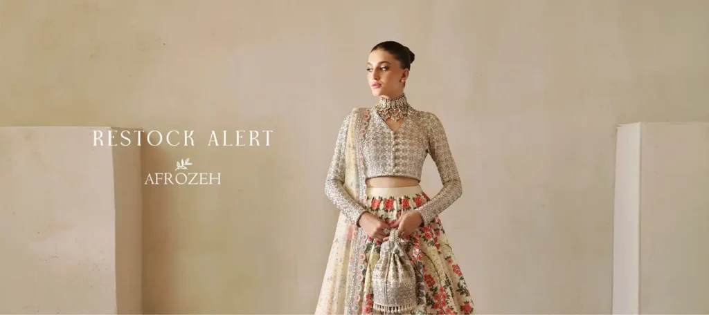 Shop assistants carefully arrange Afrozeh garments on display racks for a seasonal launch.