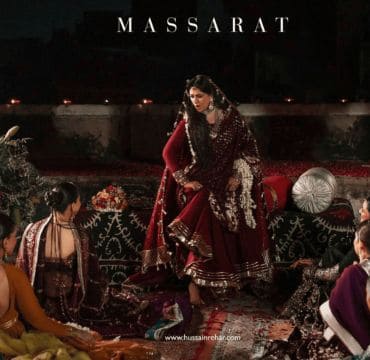 A dynamic shot from a Hussain Rehar runway show, featuring a model in a signature, brightly colored ensemble.