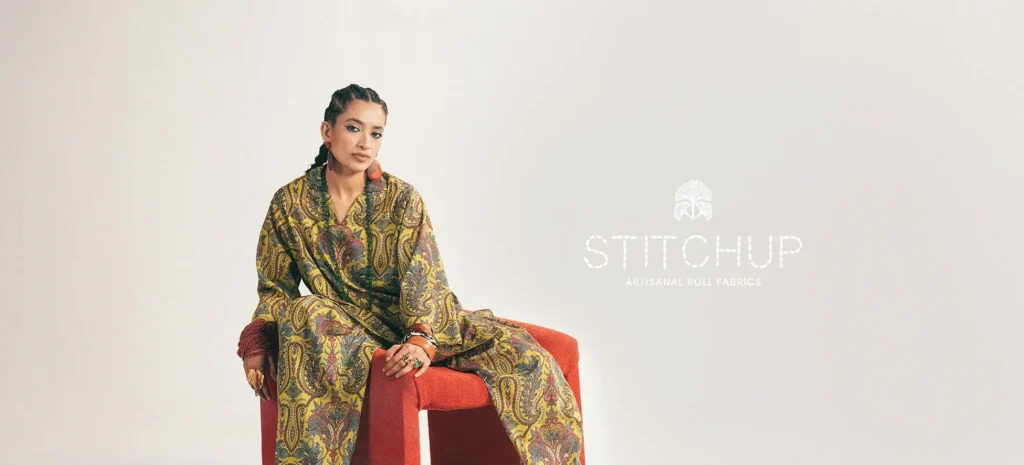 Close-up shot of artisan hands working on delicate embroidery for a Zaha garment.