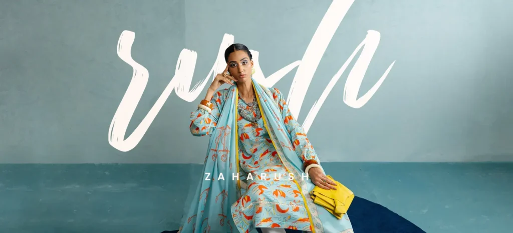 Two women laughing together, each styled uniquely in Zaha clothing, set against a backdrop of lush greenery.