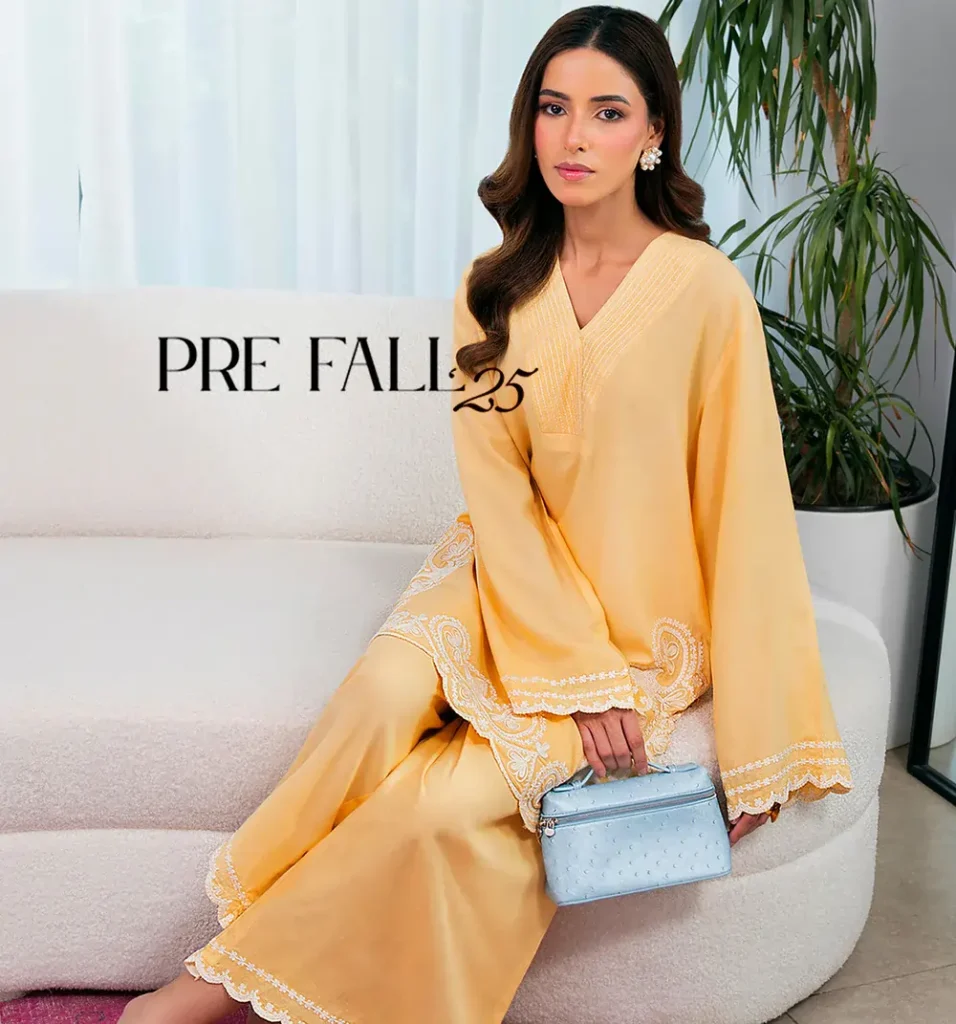 Assistants organize summer Mausummery garments on racks for the new season.